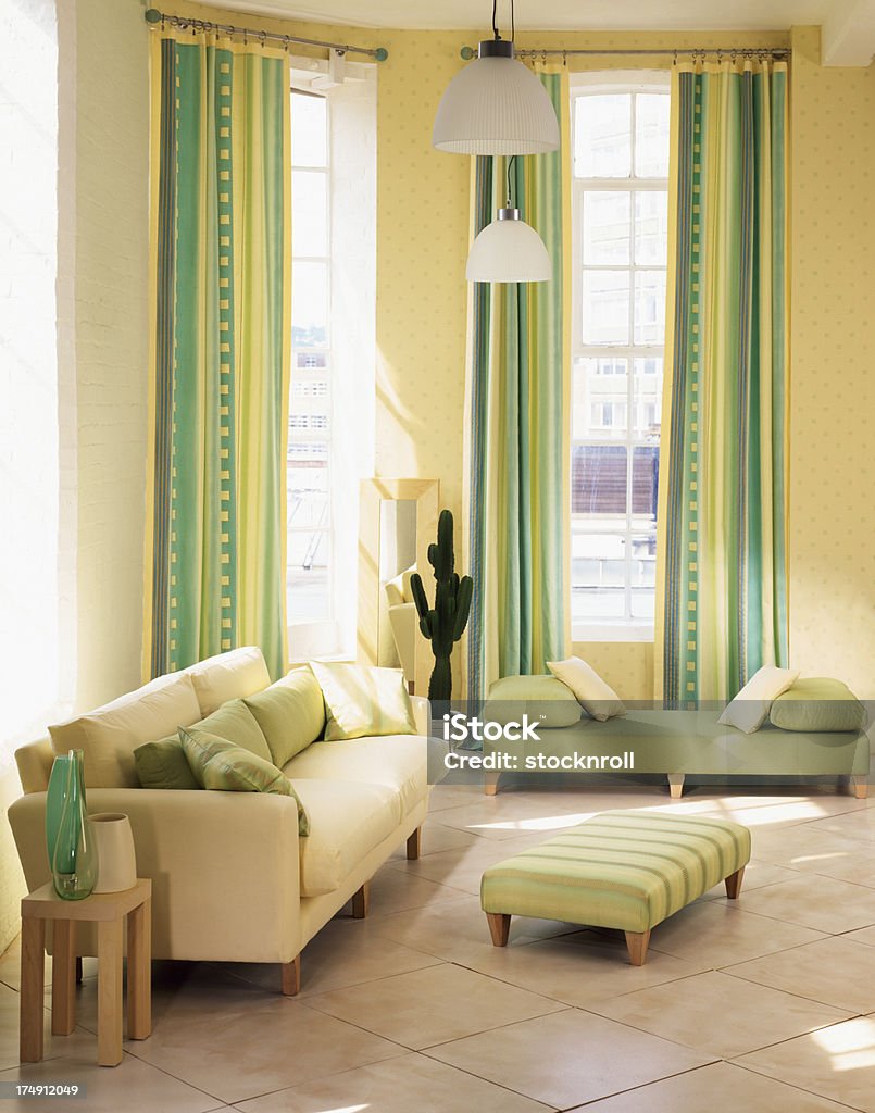 Interior of three seater sofa in living room Contempory lounge /living room with sofa, curtains and ornaments Blue Stock Photo