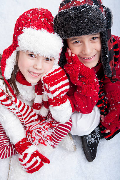 istock Siblings sitting outdoors playing in the snow 174912325