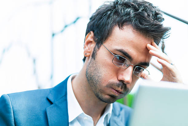 Bored tired and frustrated businessman with laptop stock photo