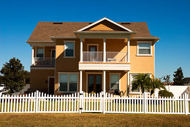 istock Yellow house and white picket fence 174912623