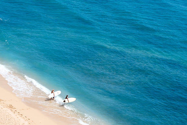 Surf Time "Two surfers heading out for a surf at Diamond Head beach, Honolulu Hawaii." waikiki hawaii stock pictures, royalty-free photos & images