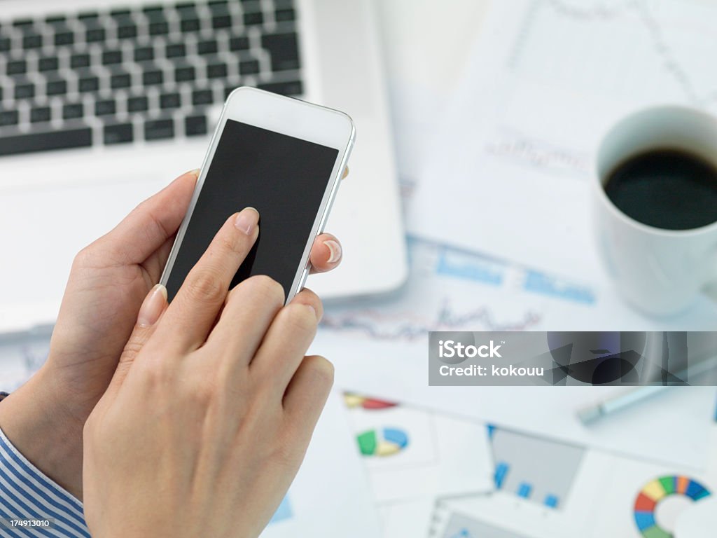 Mulher de negócios que tampers com telefone inteligente durante o trabalho - Foto de stock de Adulto royalty-free