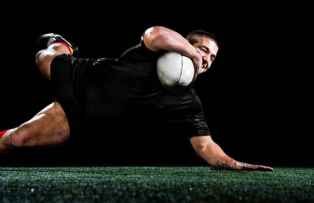 Rugby player isolated on black. Young aggressive rugby player in action. Isolated on black. Touchdown stock pictures, royalty-free photos & images