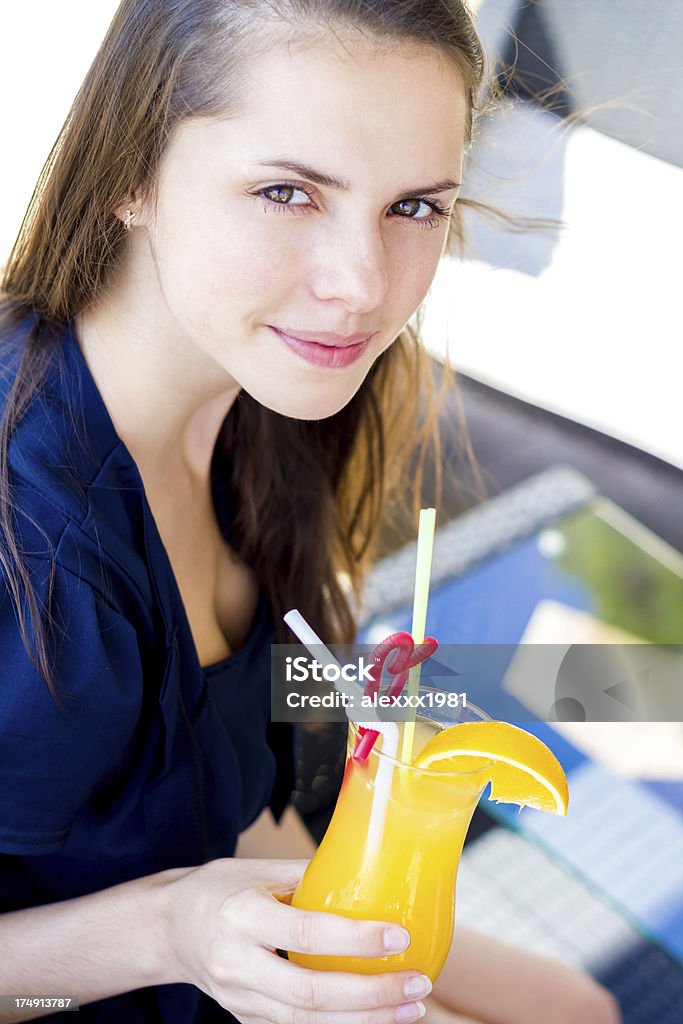 Mujer joven con jugo de naranja mirando a la cámara - Foto de stock de Actividades recreativas libre de derechos