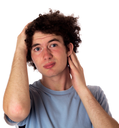 lop-eared teenager with a bored look on his face and downcast appearance showing his ear. Isolated on white.