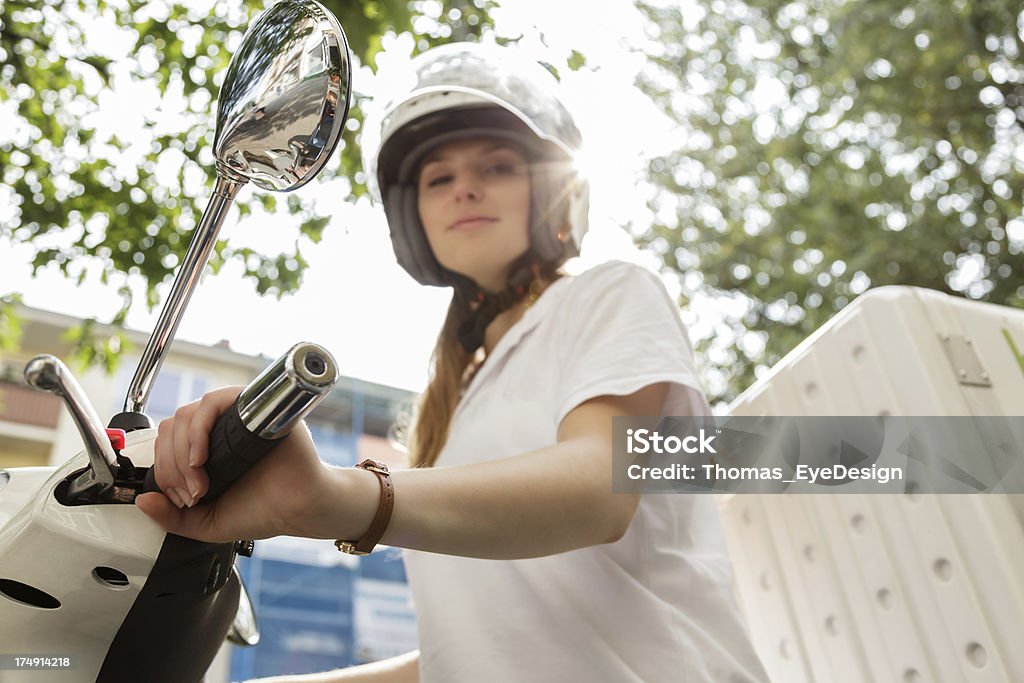 Delivering fast food on Motor scooter Young fast food delivery person  sitting on motor scooter. Horizontal shot.  Helmet Stock Photo