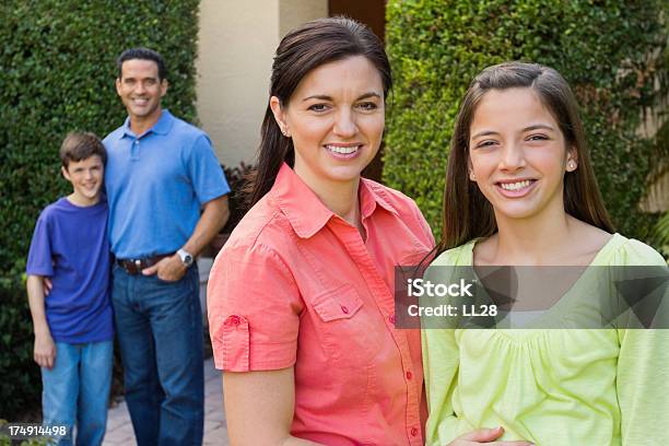 Happy Family Standing En El Jardín Delantero Foto de stock y más banco de imágenes de 14-15 años - 14-15 años, 30-39 años, Adolescente