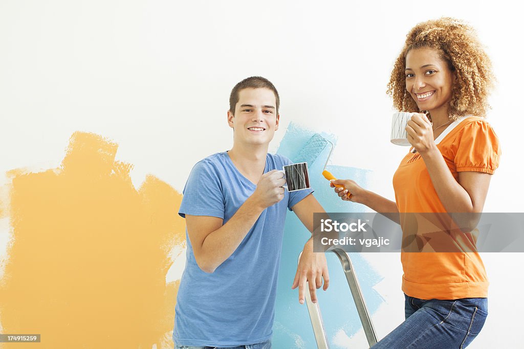 Feliz pareja joven pintar la pared. - Foto de stock de Actividad libre de derechos