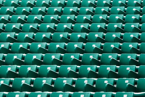 Rows of stadium seating in winter with bits of ice and snow.