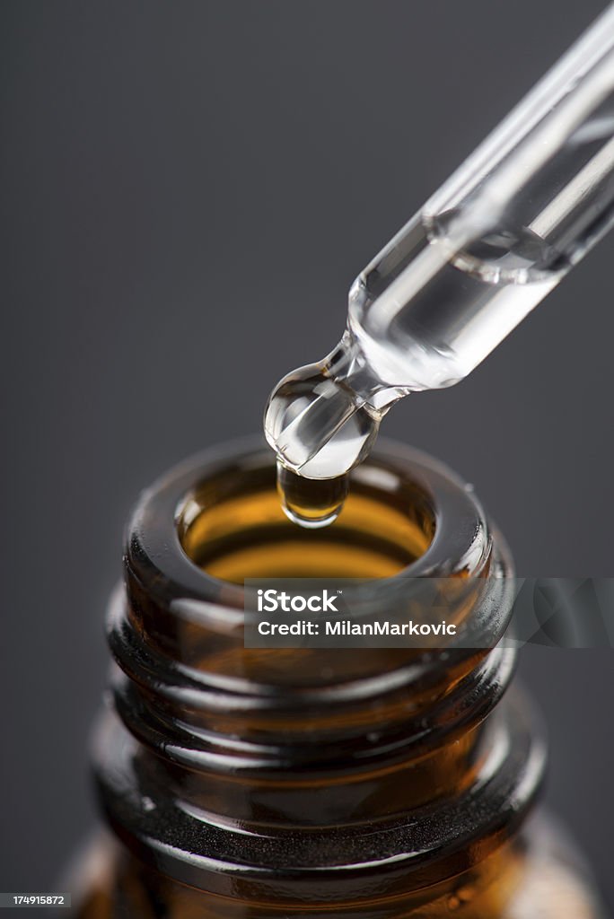 Essential liquid Brown glass bottles with drops Essential liquid in dropper. Pipette Stock Photo