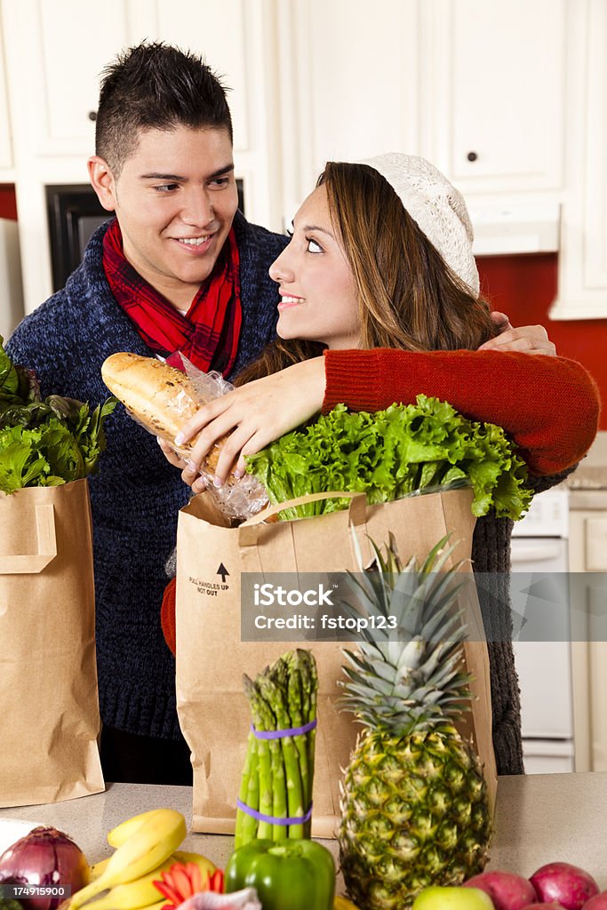 Restauration: Jeune couple dans la cuisine latino-américaine déballage de l'épicerie légumes. - Photo de 20-24 ans libre de droits