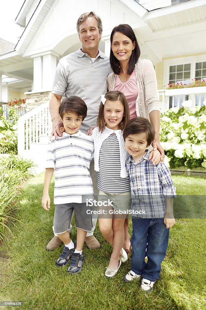 Questa famiglia felice ha una grande casa - Foto stock royalty-free di Abbigliamento casual