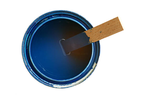 Medium sized opened can with blue paint and wooden stirrer stock photo