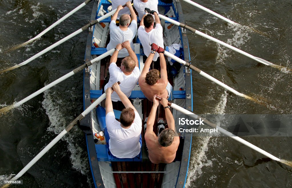 Lavoro di squadra in una barca a remi - Foto stock royalty-free di Remare