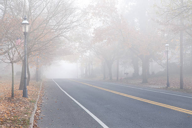cidade pequena comunidade highway in the fog - street light fog morning country road - fotografias e filmes do acervo