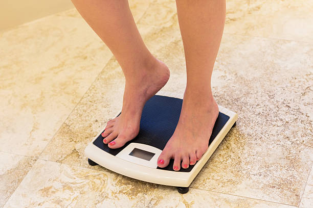 istock Woman Standing On Bathroom Scale 174917121