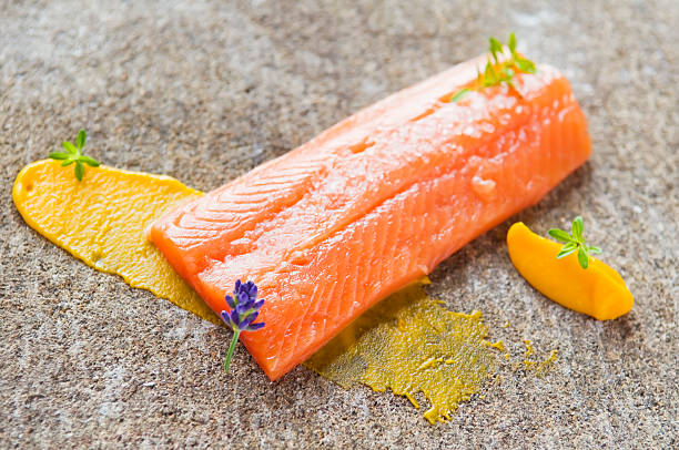 Delicious salmon Salmon prepared to cook with herbs and carrot puree. Shallow dof. bull trout stock pictures, royalty-free photos & images