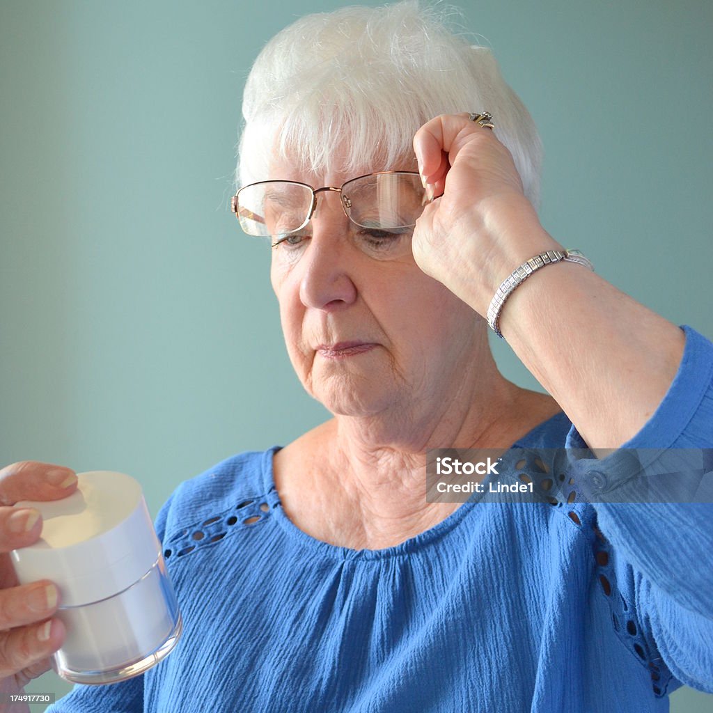 Atrakcyjne Starsza kobieta Patrząc na pojemniku - Zbiór zdjęć royalty-free (60-69 lat)