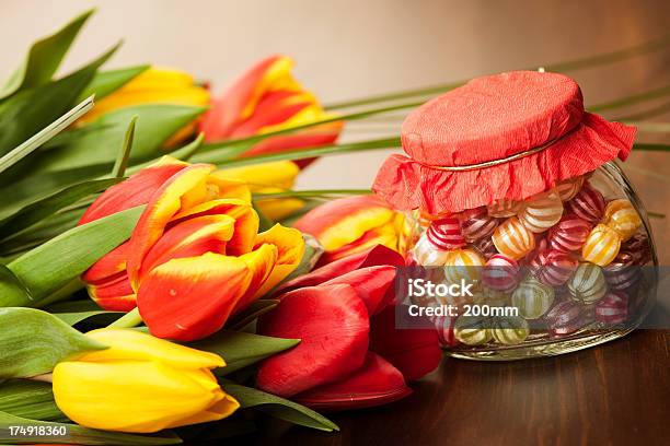 Colorful Tulips And Candies On A Wooden Surface Stock Photo - Download Image Now - Candy, Candy Cane, Celebration Event