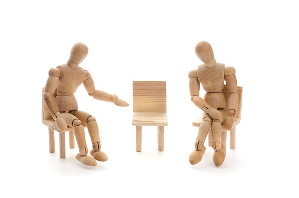 istock Wooden mannequins and empty chair 174918762
