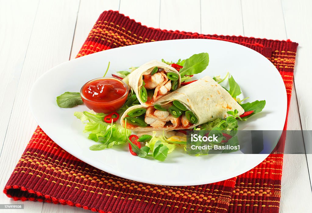 mexican fajitas (tortilla wrap) mexican fajitas (tortilla wrap) cut in two parts on a white plate Appetizer Stock Photo