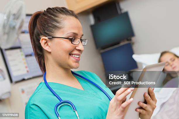 Enfermeira Felizmente Usando Tablet Digital Na Sala De Doentes Hospitalares - Fotografias de stock e mais imagens de Cama