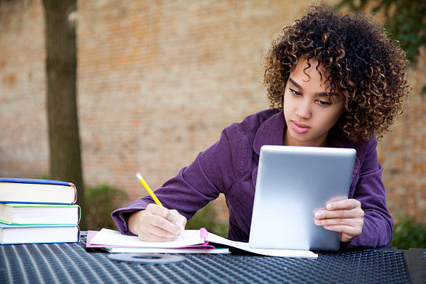 Woman using a digital tablet to study stock photo