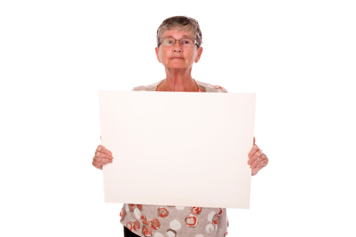 A lady in her 60's holding a blank sign isolated on white. Add your own text.