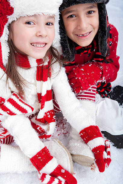 istock Siblings sitting outdoors playing in the snow 174921689