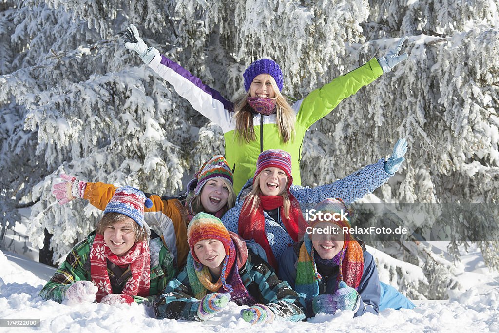 Grupo de jovens feliz deitado na neve - Foto de stock de 20 Anos royalty-free