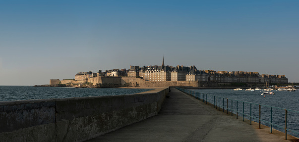 From the end of a walkway extending from the ancient port of Saint-Malo in northwestern France, a panorama of the entire walled city is visible.