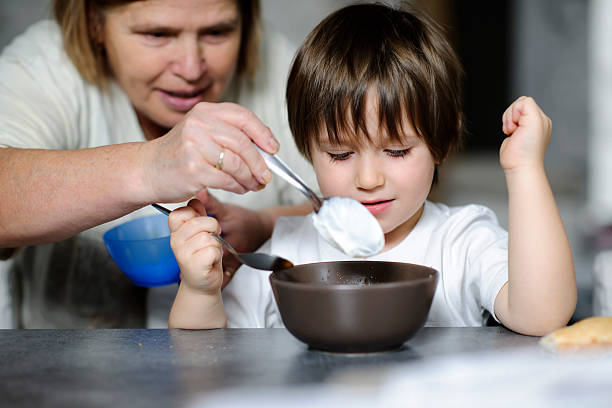 lunch you young boy preparing to eat. grandmother real people front view head and shoulders stock pictures, royalty-free photos & images