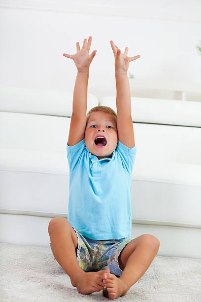istock Boy sitting on the floor with arms up 174922956