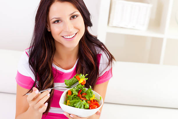 istock Young woman eating a salad 174923261