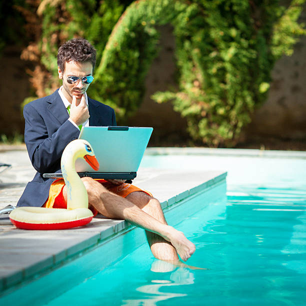 istock Businessman using laptop and relaxing in swimming pool 174923321