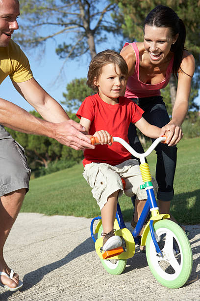 istock Parents Teaching Son To Ride Bike In Park 174923737