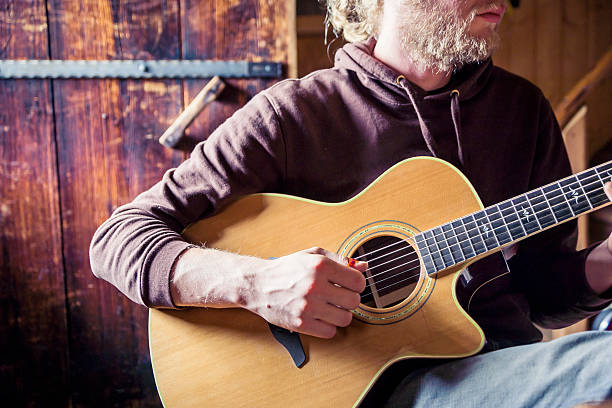 istock Young Man Playing Acoustic Guitar 174923837