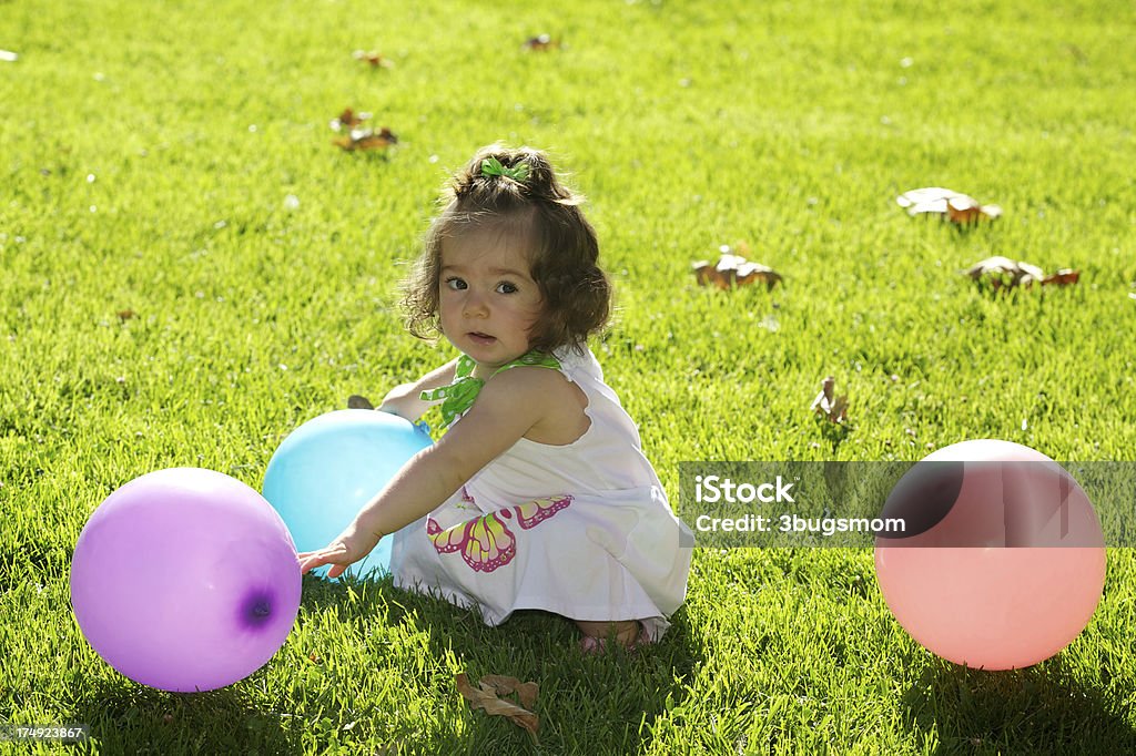 Lindo bebê menina sentada na grama com balões - Foto de stock de 12-23 meses royalty-free