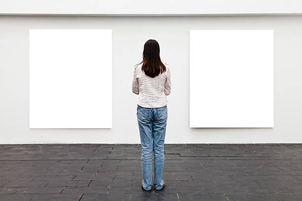 istock One woman looking at white frame in an art gallery 174924265