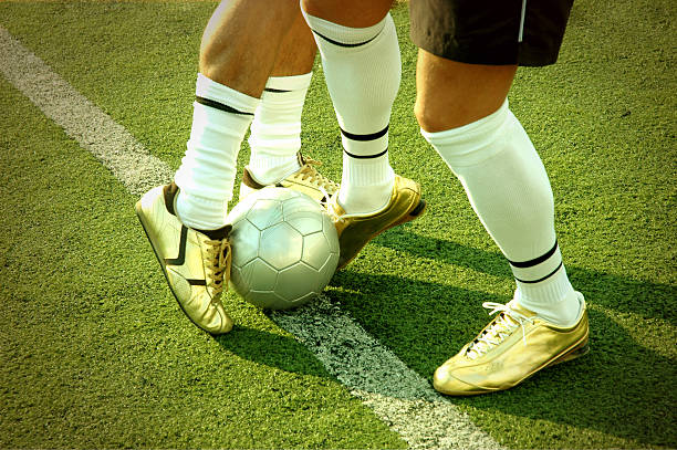 Blocked Istockalypse Barcelona: Two players blocking a ball during a soccer/football game on the edge of the penalty box. football socks stock pictures, royalty-free photos & images