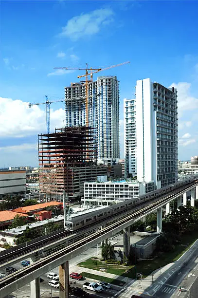 miami lofts highrise construction and passing metrorail train