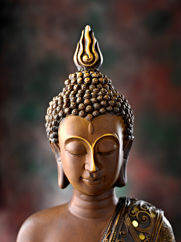 Meditating Buddha Statue on dark background. Close up. Copy space.