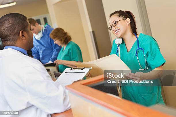 Foto de Enfermeira No Telefone E Olhando Registros Para Médico e mais fotos de stock de Posto das Enfermeiras