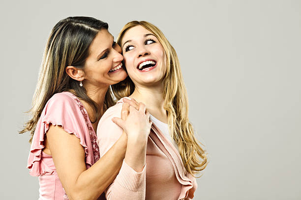 Portrait of mother and young adult daughter at park in sunny day