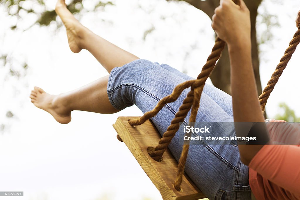 Mujer joven en jeans azul sobre swing - Foto de stock de 20 a 29 años libre de derechos