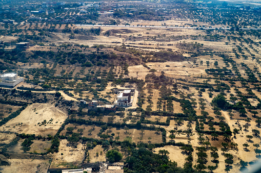 Aerial view of Kayakoy, Turkey, showcasing old abandoned and ruined buildings, with lush vegetation taking over the surrounding area