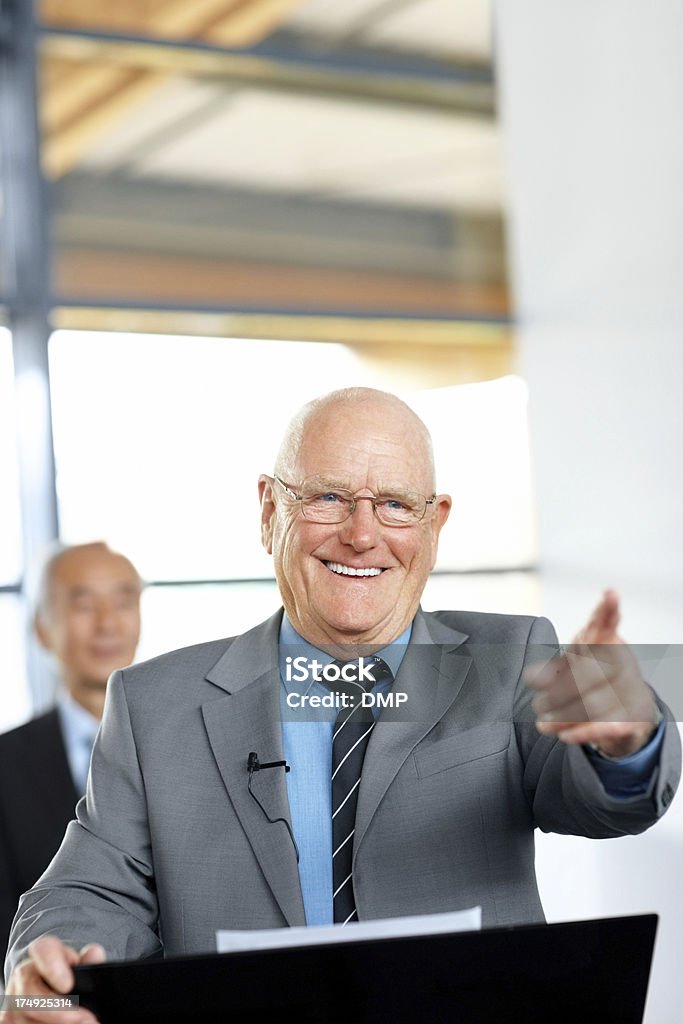 Uomo d'affari Senior affrontare il pubblico a una conferenza - Foto stock royalty-free di Adulto in età matura