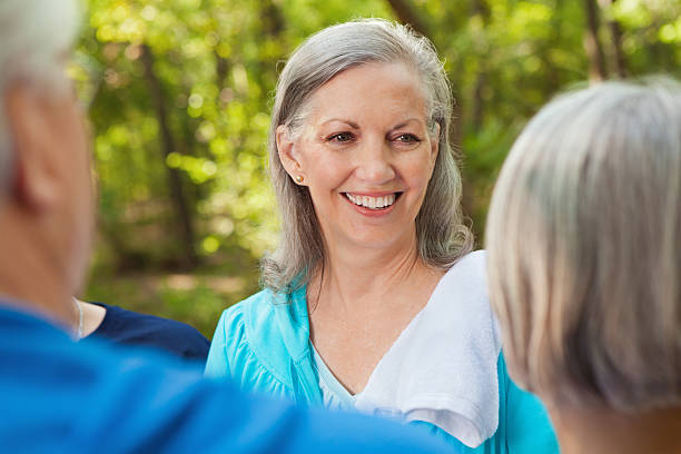 istock Active senior woman talking with friends during outdoor exercise class 174925674