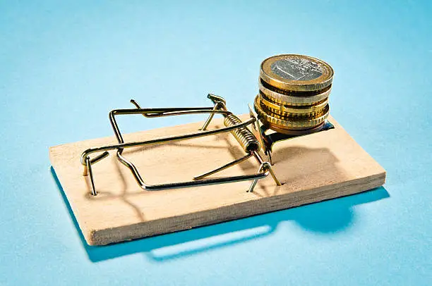 "Mousetrap with Euro Coins stack, isolated on blue."