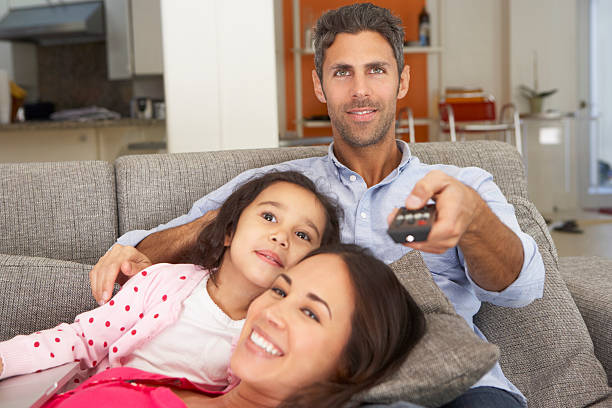 istock Family Sitting On Sofa And Watching TV 174926142